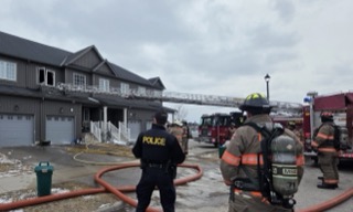 Firefighters and police at a house fire.