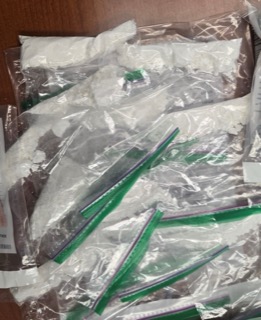 Green and purple plastic straws in a clear plastic bag.