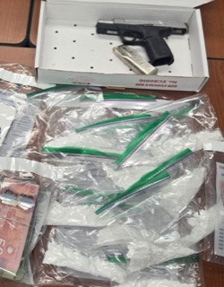 Firearm in a red evidence box, surrounded by cash and plastic bags.