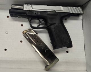 Firearm and magazine on a white surface.