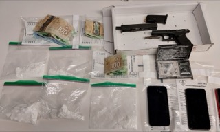 Canadian currency, ammunition, two handguns, plastic baggies, and a black wallet in a box.