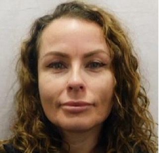 Woman with curly brown hair and hazel eyes.