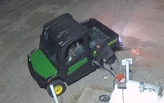Black and green utility vehicle at a gas station