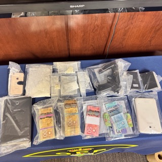Several smartphones and Canadian currency.