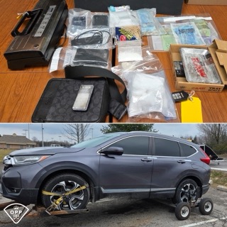 Firearm, scales, bags, and boxes on a wooden surface. Black SUV with aftermarket wheels.