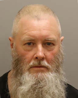Man with a shaved head and full, gray beard.