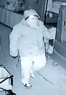 Person wearing a hooded sweatshirt and pants, holding a cane.