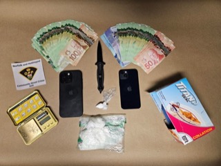 Canadian currency, two smartphones, a knife, small baggies, a wallet, and a box of plastic bags.