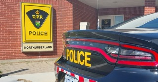 OPP police cruiser parked in front of a brick building.