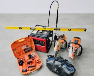 Red generator, toolbox, and two orange chainsaws in a black bag.
