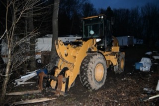 Yellow front-end loader in a yard.