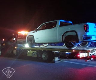 White pickup truck on a tow truck.
