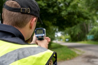Person holding a speed detection device.