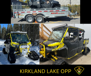 Yellow side-by-side ATV covered in snow, trailer in background