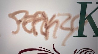 Brown spray-painted graffiti.