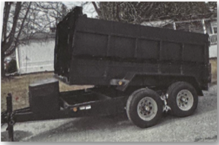 Black dump trailer with dual rear wheels