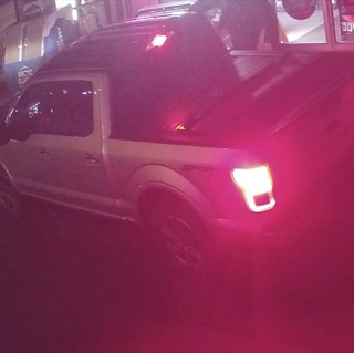 Red and purple light reflecting on a dark vehicle