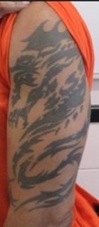 Black brushstroke tattoo on a person's side
