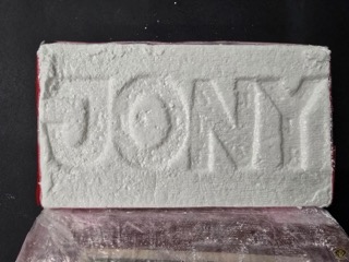 Block of white powder, partially wrapped in red plastic