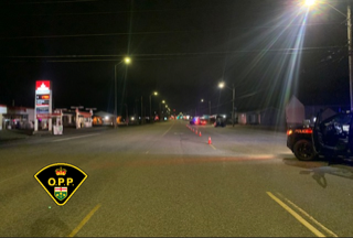 Police cruiser, orange traffic cones, dark road