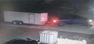 Trailer and a blurred vehicle with red taillights.