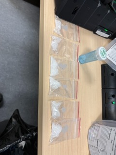 Small baggies of white powder arranged in a row.