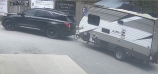 Black SUV towing a trailer.