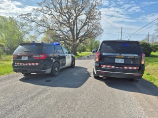 Two police SUVs parked on a residential street.