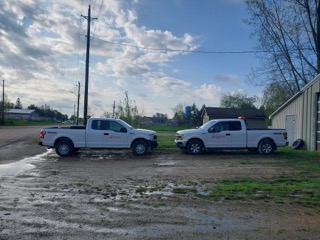 Two white pickup trucks with Veolia logos.