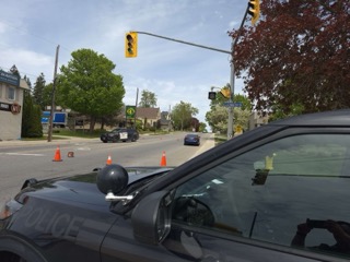 Black SUV windshield view, traffic cones, street, traffic light, houses, trees