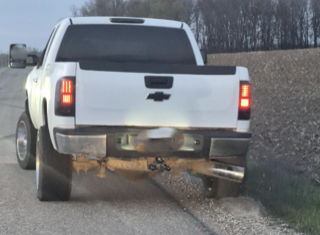 White pickup truck with chrome bumper and exhaust pipes.