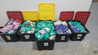 Black plastic bins filled with small, colorful packets.