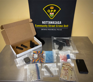 Four handguns in a box, Canadian currency, small baggies, and a smartphone.