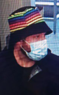 Person wearing a colorful, striped hat and a face mask.