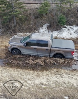 Brown pickup truck with a camper shell in snow