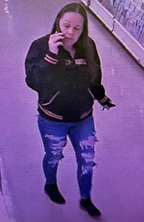 Person on phone, wearing a black jacket and jeans