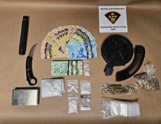 Canadian money, baggies of suspected drugs, a knife, scissors, and a magazine.